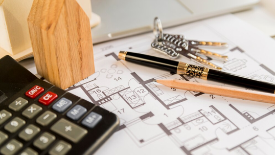 a calculator, floor plan paper, and pens.