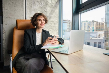 A woman at her desk looking out the window.