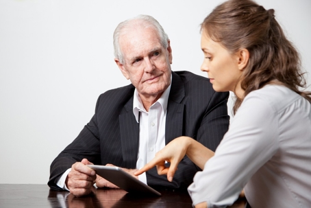 a woman talking to an older man.