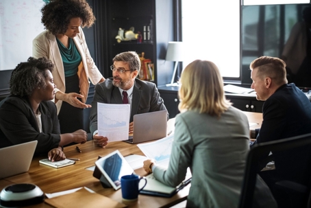 a group of people talking at a conference table.